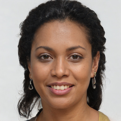 Joyful black young-adult female with long  brown hair and brown eyes