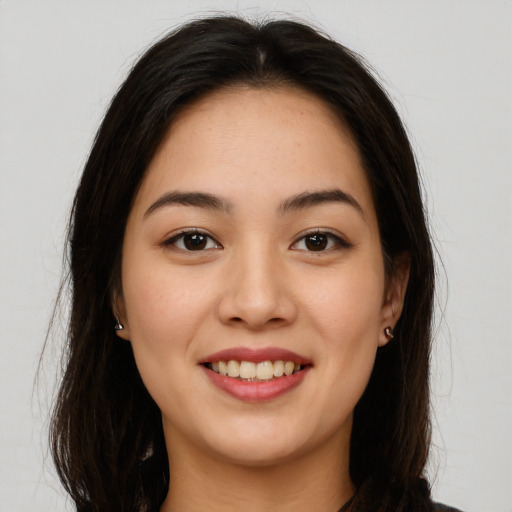 Joyful latino young-adult female with long  brown hair and brown eyes