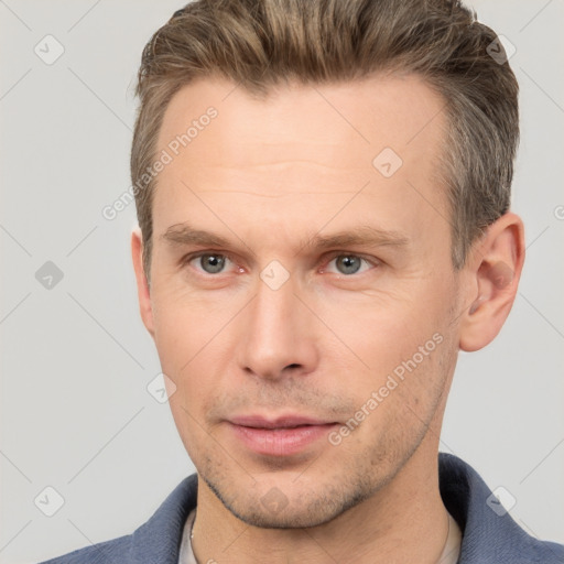 Joyful white adult male with short  brown hair and grey eyes