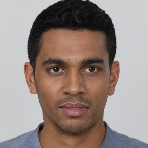 Joyful black young-adult male with short  black hair and brown eyes