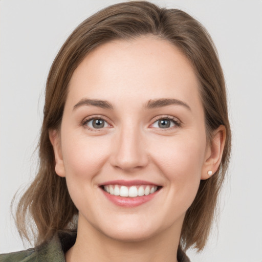 Joyful white young-adult female with medium  brown hair and grey eyes