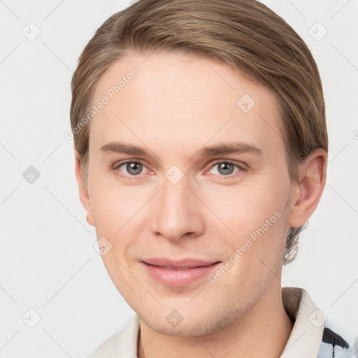 Joyful white young-adult male with short  brown hair and grey eyes