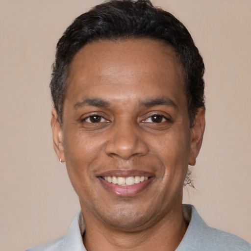 Joyful black adult male with short  black hair and brown eyes