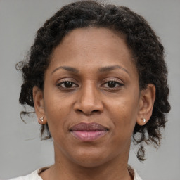 Joyful black adult female with medium  brown hair and brown eyes