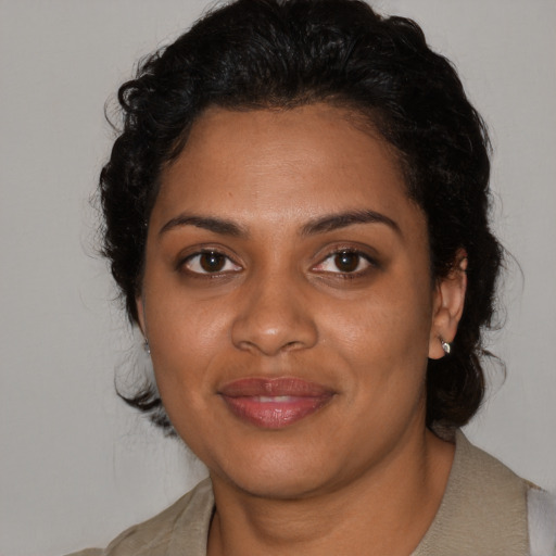 Joyful black young-adult female with medium  black hair and brown eyes