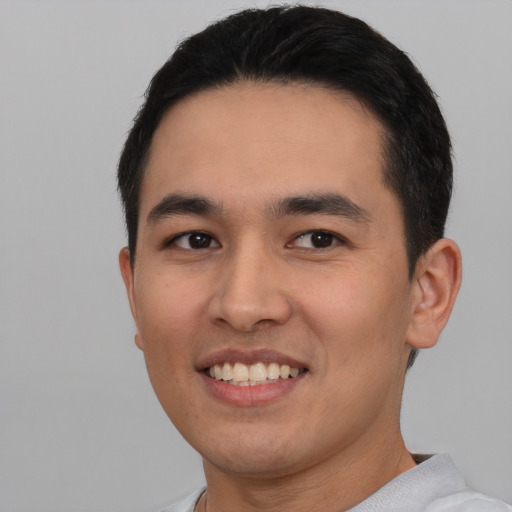 Joyful white young-adult male with short  black hair and brown eyes
