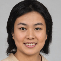 Joyful asian young-adult female with medium  brown hair and brown eyes