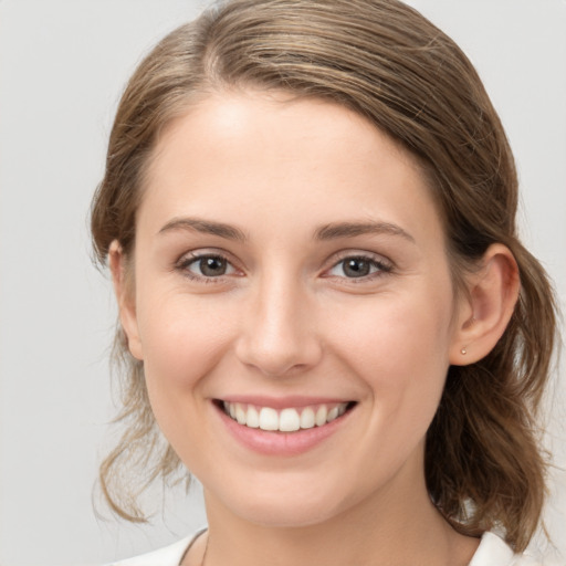 Joyful white young-adult female with medium  brown hair and grey eyes