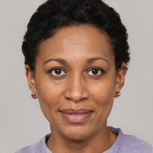 Joyful black adult female with short  black hair and brown eyes