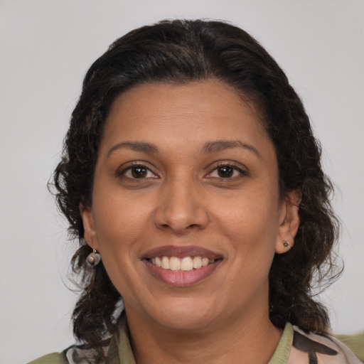 Joyful latino adult female with medium  brown hair and brown eyes