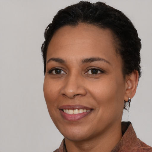 Joyful latino young-adult female with short  black hair and brown eyes