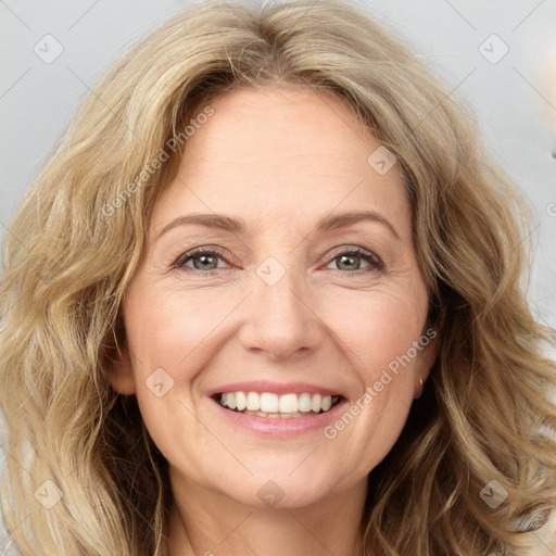 Joyful white adult female with long  brown hair and green eyes