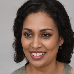 Joyful black young-adult female with medium  brown hair and brown eyes