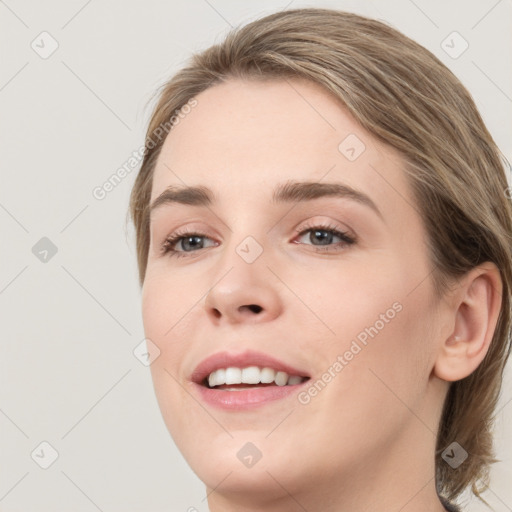 Joyful white young-adult female with medium  brown hair and grey eyes