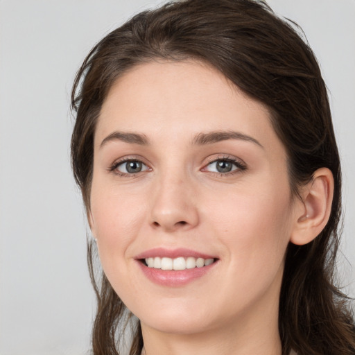 Joyful white young-adult female with long  brown hair and grey eyes