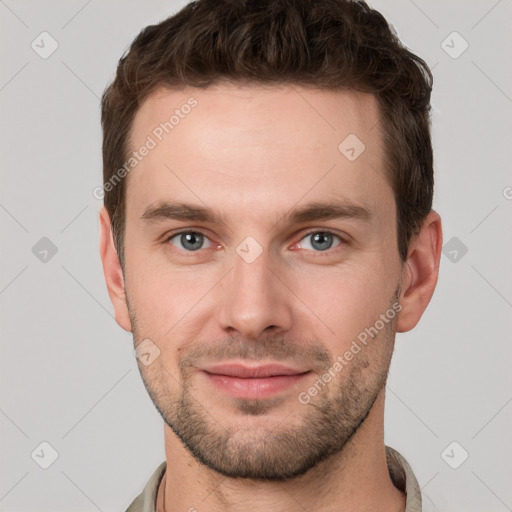 Joyful white young-adult male with short  brown hair and grey eyes