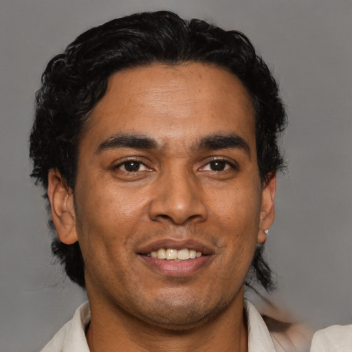 Joyful latino adult male with short  black hair and brown eyes