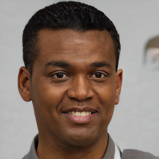Joyful black young-adult male with short  black hair and brown eyes