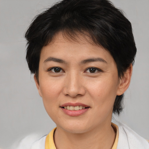 Joyful asian young-adult female with short  brown hair and brown eyes