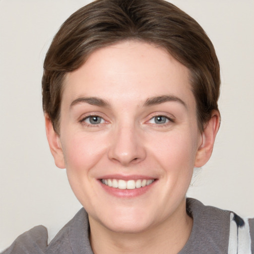 Joyful white young-adult female with short  brown hair and grey eyes