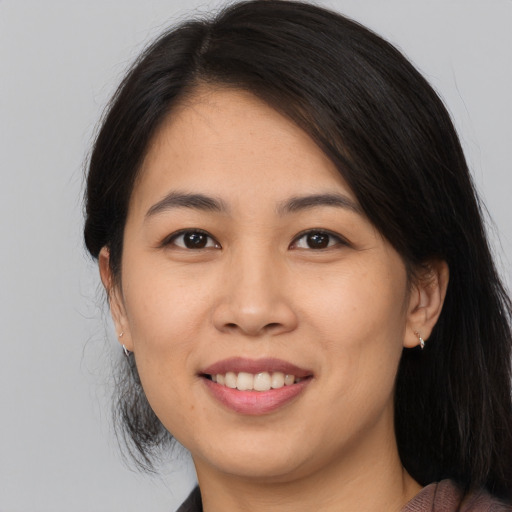 Joyful asian young-adult female with long  brown hair and brown eyes