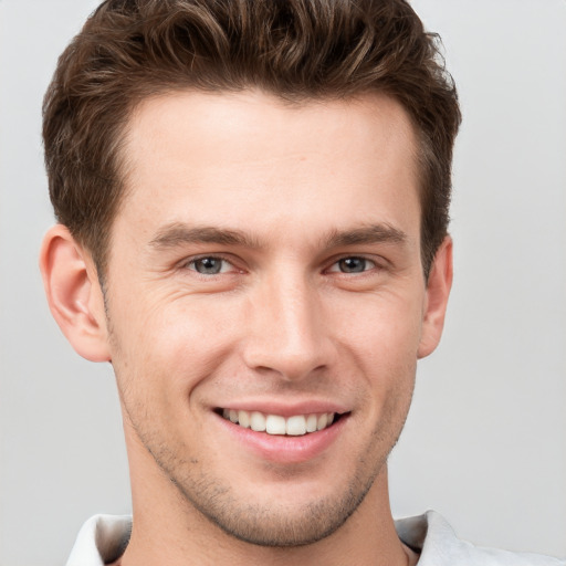 Joyful white young-adult male with short  brown hair and grey eyes