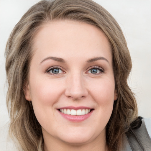 Joyful white young-adult female with long  brown hair and blue eyes