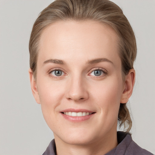 Joyful white young-adult female with medium  brown hair and blue eyes