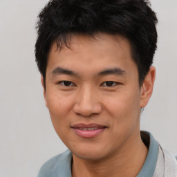 Joyful asian young-adult male with short  brown hair and brown eyes