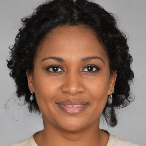 Joyful black young-adult female with medium  brown hair and brown eyes