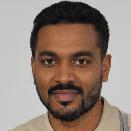 Joyful black young-adult male with short  black hair and brown eyes