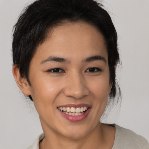 Joyful latino young-adult female with medium  brown hair and brown eyes