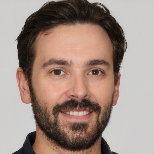 Joyful white adult male with short  brown hair and brown eyes