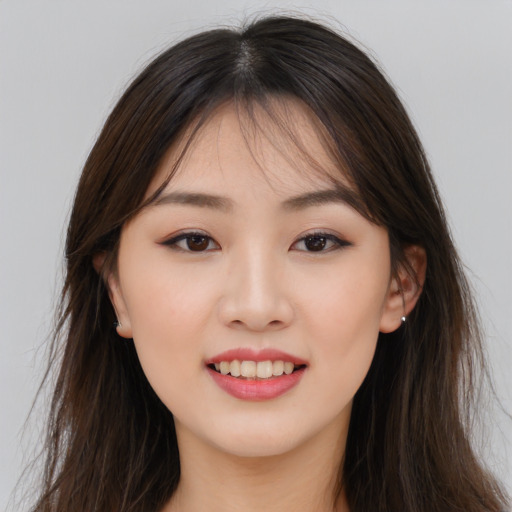 Joyful asian young-adult female with long  brown hair and brown eyes