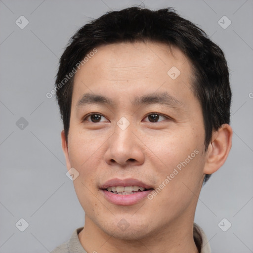 Joyful asian young-adult male with short  brown hair and brown eyes