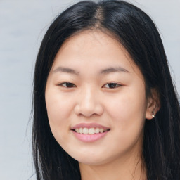 Joyful asian young-adult female with long  brown hair and brown eyes