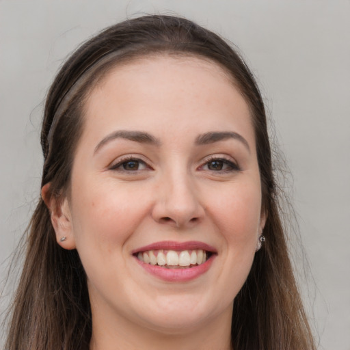 Joyful white young-adult female with long  brown hair and grey eyes