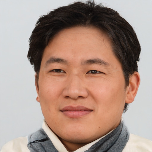 Joyful asian adult male with short  brown hair and brown eyes