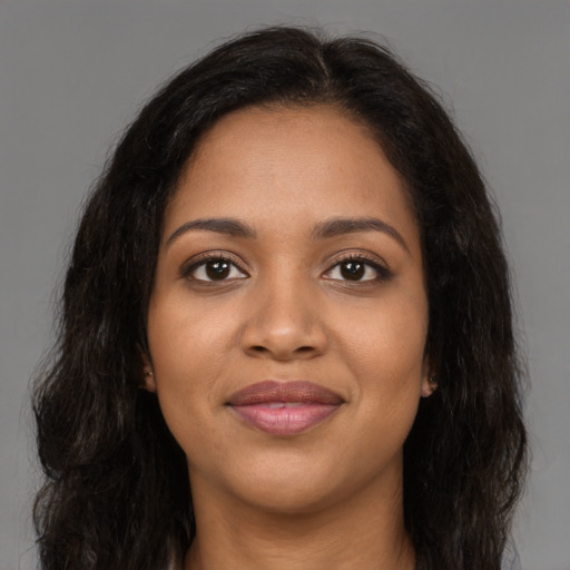 Joyful black young-adult female with long  brown hair and brown eyes