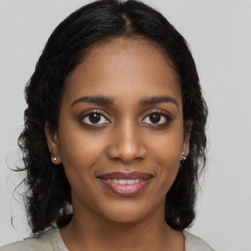 Joyful black young-adult female with long  black hair and brown eyes