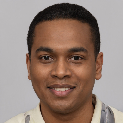 Joyful black young-adult male with short  black hair and brown eyes