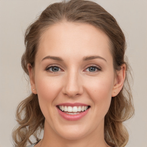 Joyful white young-adult female with long  brown hair and blue eyes