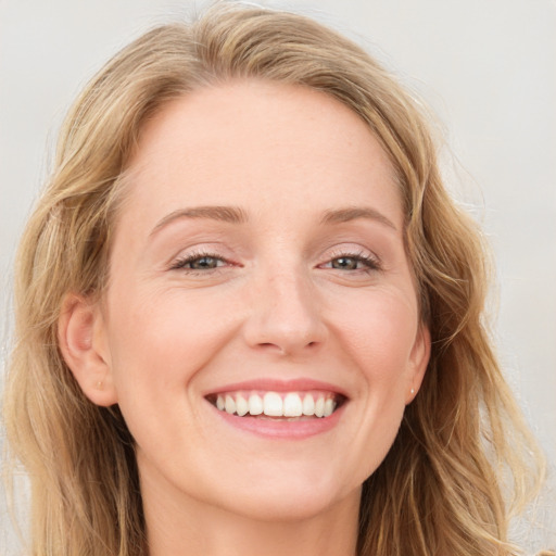 Joyful white adult female with long  brown hair and blue eyes