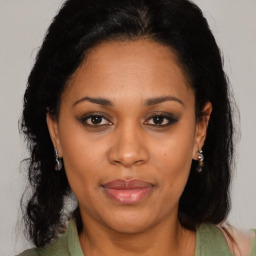 Joyful black adult female with medium  brown hair and brown eyes