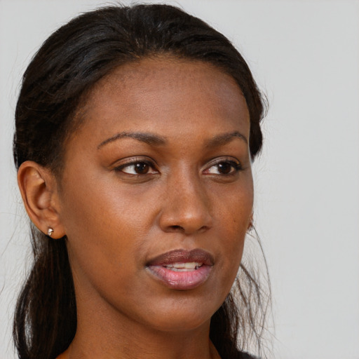 Joyful black young-adult female with long  brown hair and brown eyes