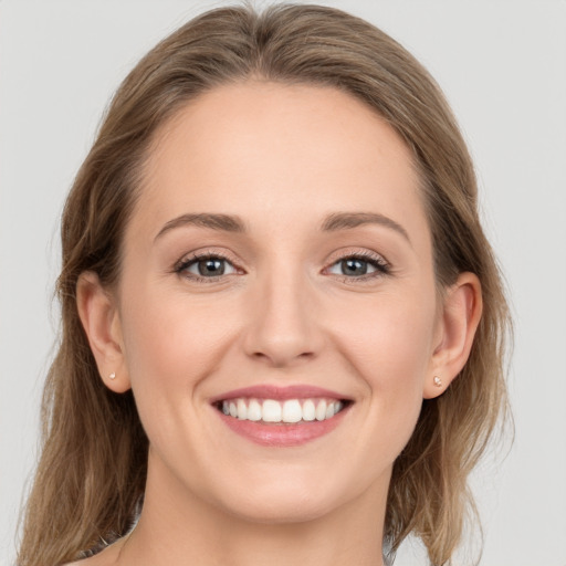 Joyful white young-adult female with medium  brown hair and grey eyes