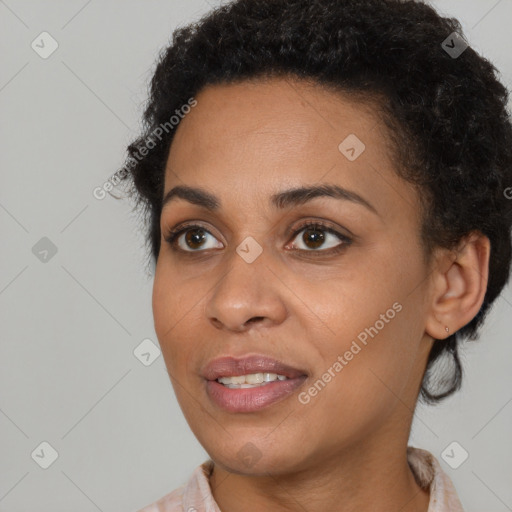 Joyful black young-adult female with short  brown hair and brown eyes