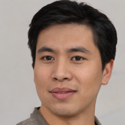 Joyful asian young-adult male with short  black hair and brown eyes