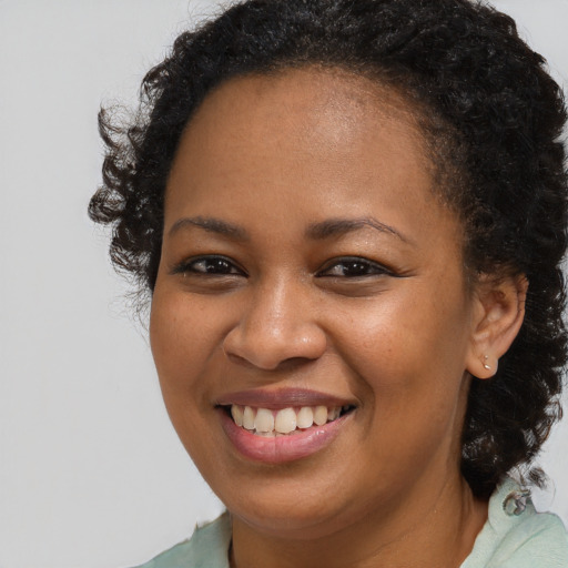 Joyful black young-adult female with long  brown hair and brown eyes