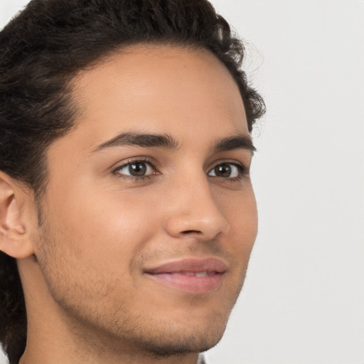 Joyful latino young-adult male with short  brown hair and brown eyes